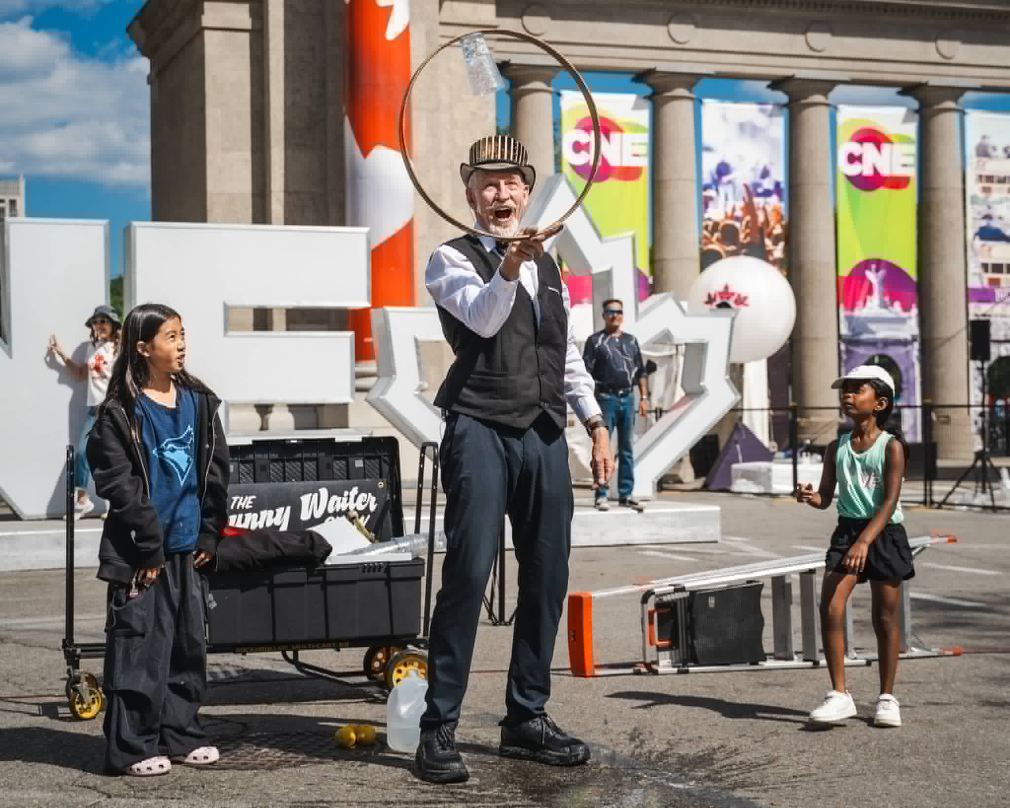 Balancing a glass of water inside a spinning hoop with young volunteers at the CNE