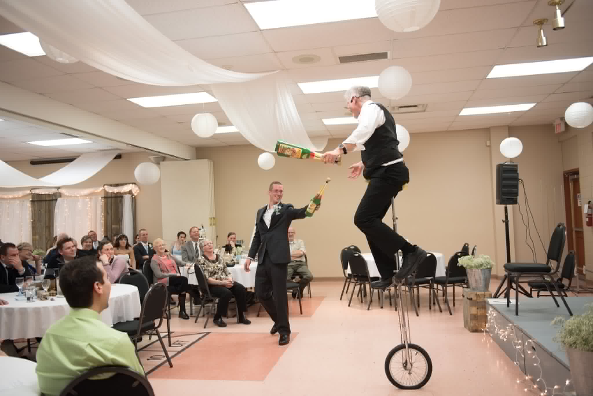 Wedding reception entertainment: unicycle and champagne bottle juggling with the groom